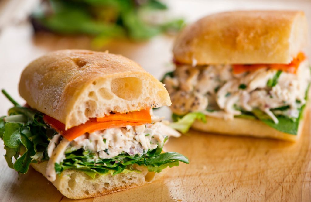 Healthy chicken and egg sandwich with multigrain bread and diced vegetables.