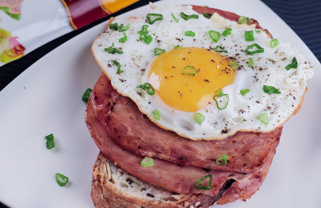 Toasted chicken and egg sandwich with salami and cheese on whole wheat bread.