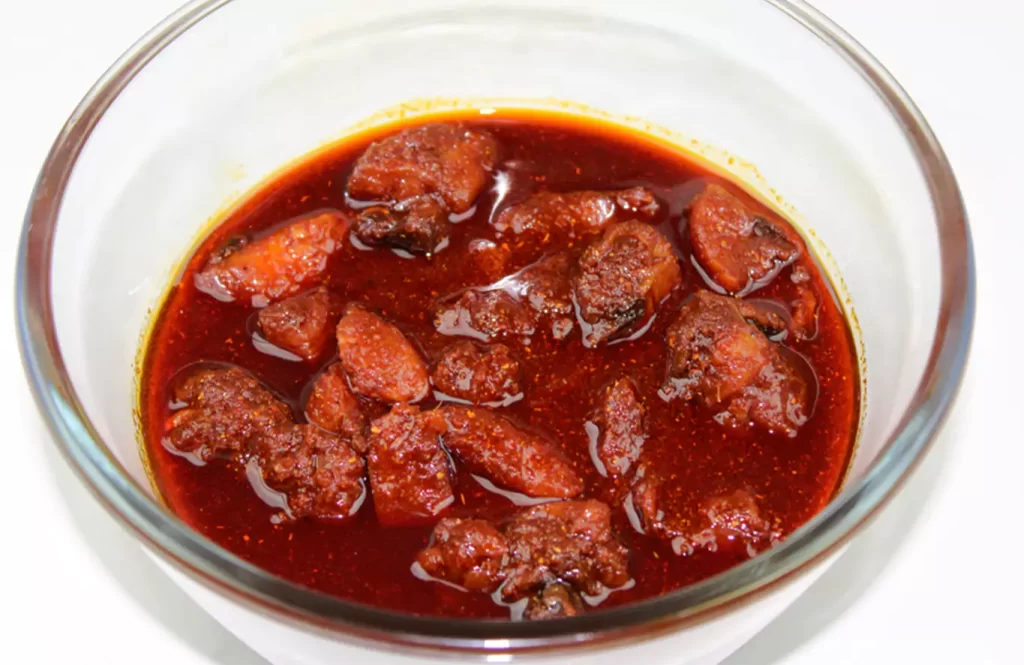 Spicy homemade chicken pickle in a glass bowl.