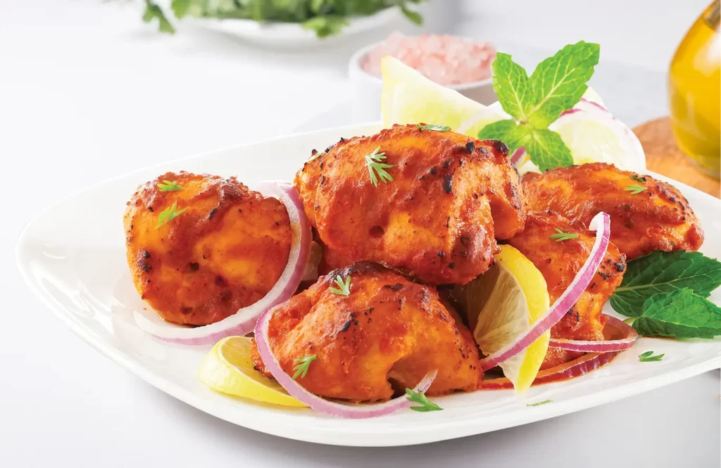 Smoky grilled chicken pieces with rich spices on a plate.