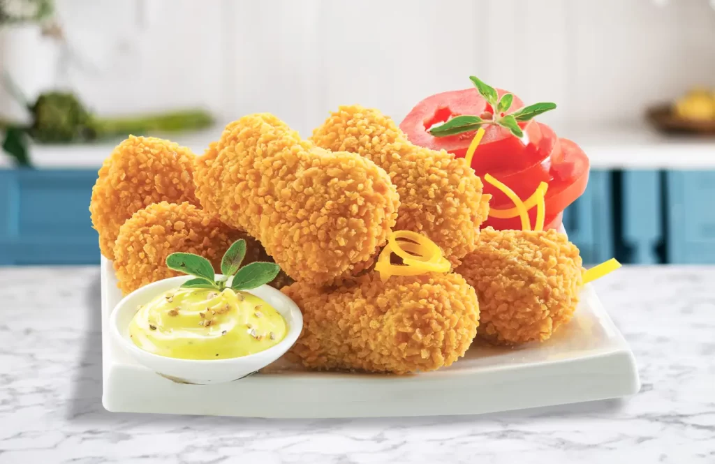 Classic crispy chicken nuggets with a side of creamy dip and fresh vegetables.
