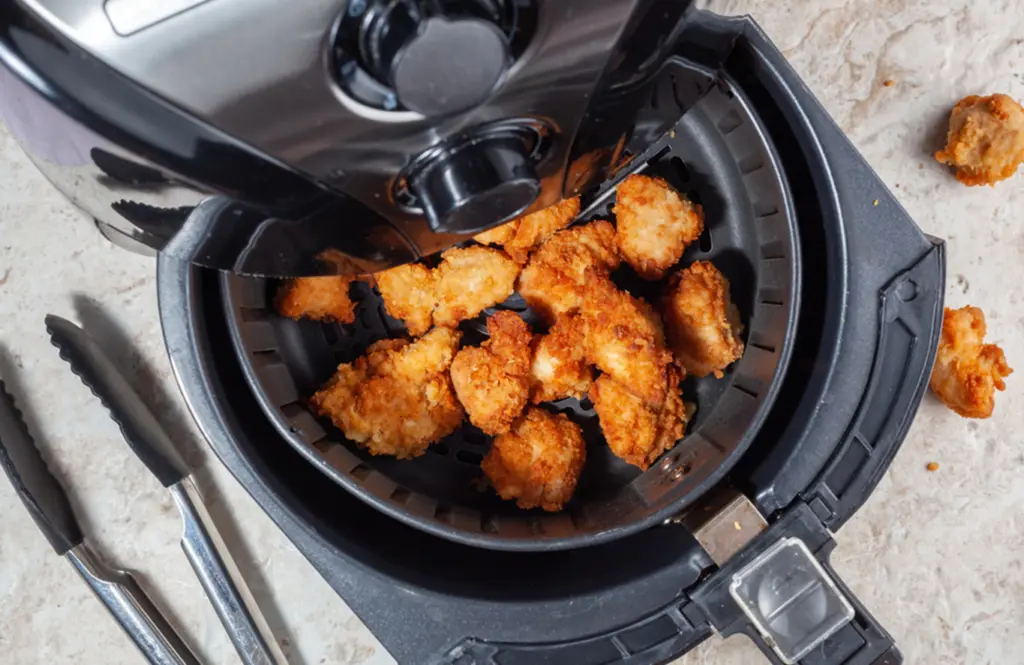 Crispy air-fried chicken in an air fryer basket, golden brown and ready to serve, fresh from cooking